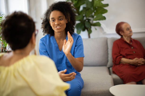 istock Nursing assistant talking with senior woman in nursing home 1345132383