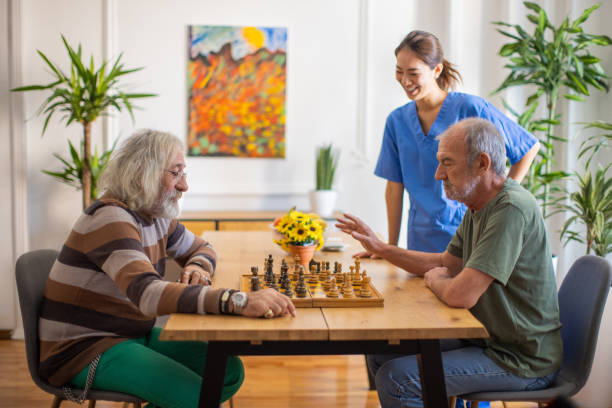 istock Senior man planning next move while playing chess with friend at nursing home 1345133718
