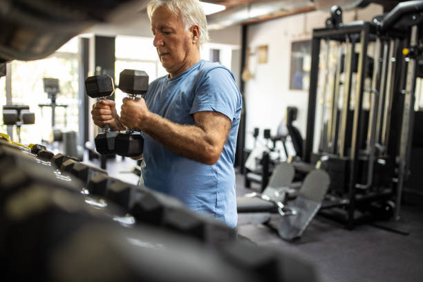 istock Senior man taking dumbbells for next exercise in gym 1345133802