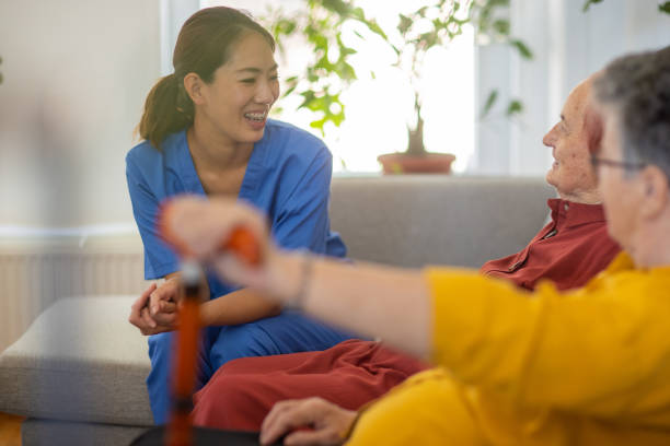 istock Nursing assistant having a pleasant conversation with two senior women in nursing home 1345136184