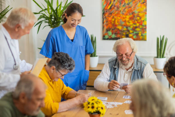 istock Happy senior people playing card at nursing home 1345136952