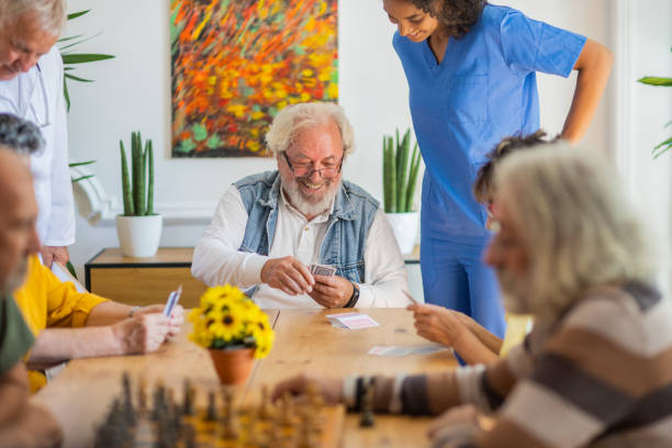 istock Happy senior people playing card at nursing home 1345138581