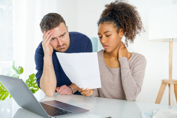 istock Young biracial couple with calculator looking at their finance problems 1345139259