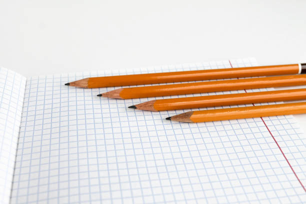 istock Pencils lie on a blank notebook sheet, white background 1345146626