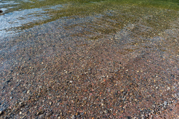 istock Small colored pebble beach under shallow water, top view, no people 1345149761