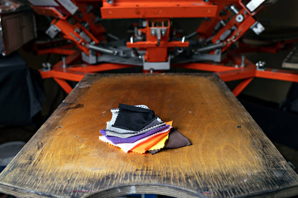 istock fabric samples on wooden shelve on the print screening apparatus. silk screen textile printery. serigraph printing production 1345150292