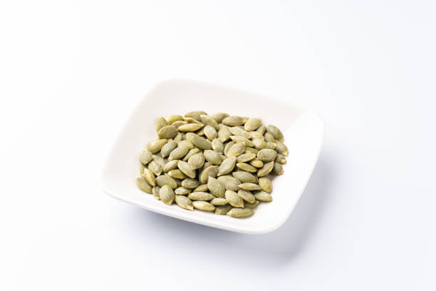 istock Edible pumpkin seeds on white background 1345150889