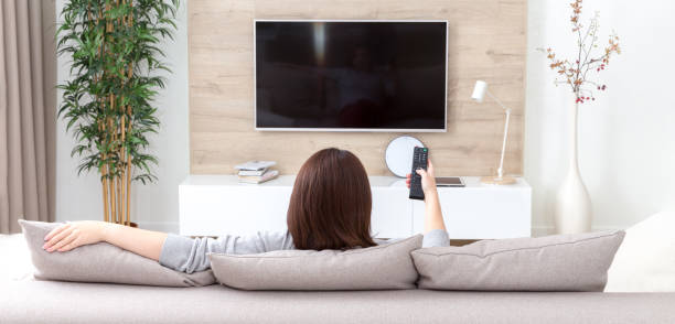 młoda kobieta oglądająca telewizję w pokoju - projection equipment home interior house living room zdjęcia i obrazy z banku zdjęć