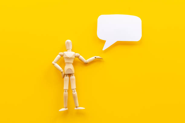 istock Wooden man figure presenting and showing on speech bubble banner 1345153598