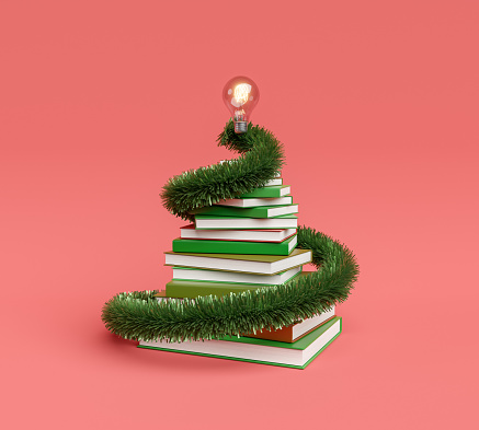 stack of books with christmas ornament and light bulb