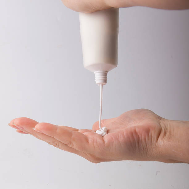 istock Applying white cream to light female hands 1345160330