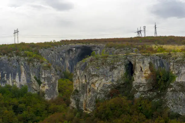 Photo of Panoramic view of entrance of Prohodna cave also known as God's eyes near Karlukovo village, Bulgaria. Colorful cave formation with giant entrance.