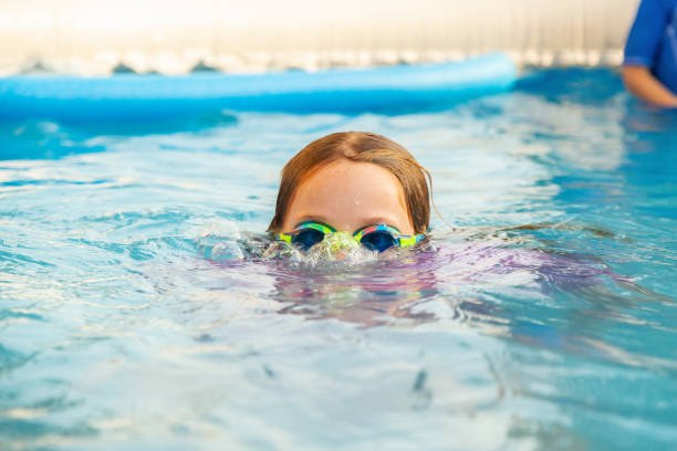 istock Girl Blowing Bubbles in Swimming Pool 1345165651
