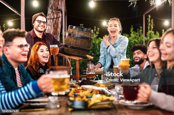 Happy Men And Women Having Fun Drinking Out At Beer Garden Social Gathering Life Style Concept On Young People Enjoying Hangout Time Together At Night Warm Filter With Shallow Depth Of Field Stock Photo - Download Image Now