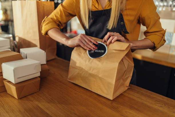 istock Woman packing food for delivery 1345169003