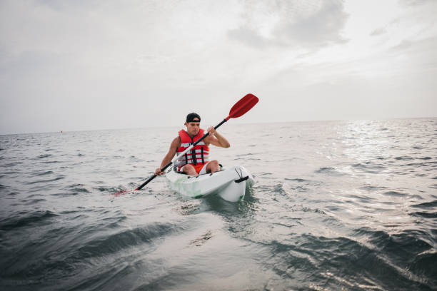 istock Young caucasian man kayaking in sea 1345169709