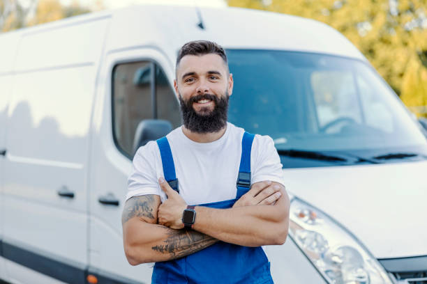 um motorista do armazém está de braços cruzados na frente da picape. ele está dirigindo e enviando mercadorias para todos os seus clientes. o cliente pode ter certeza de que a mercadoria chegará a eles a tempo. - working smiling equipment car - fotografias e filmes do acervo