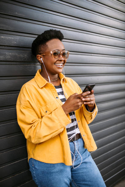 istock Young, smiling student woman using smartphone on the street 1345171862