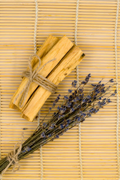 bastoncini di legno palo santo su stuoia di bambù. - lavender mint tea foto e immagini stock