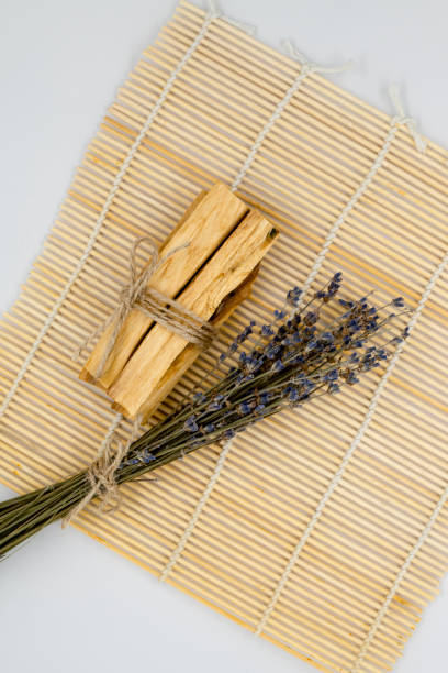 bastoncini di legno palo santo su stuoia di bambù. - lavender mint tea foto e immagini stock