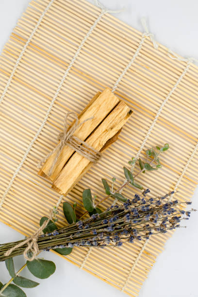 bastoncini di legno palo santo su stuoia di bambù. - lavender mint tea foto e immagini stock