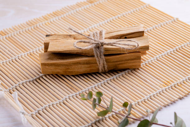 bastoncini di legno palo santo su stuoia di bambù/ - lavender mint tea foto e immagini stock