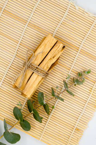 bastoncini di legno palo santo su stuoia di bambù. - lavender mint tea foto e immagini stock