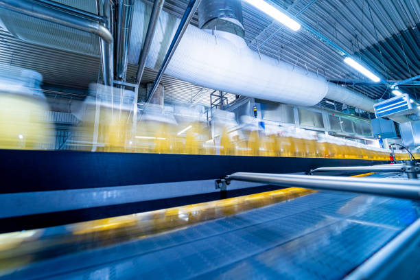 bande transporteuse avec bouteilles de jus ou d’eau dans une usine de boissons moderne - bottling plant brewery industry food photos et images de collection