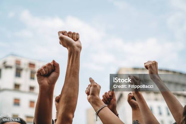 People With Raised Fists At A Demonstration In The City Stock Photo - Download Image Now