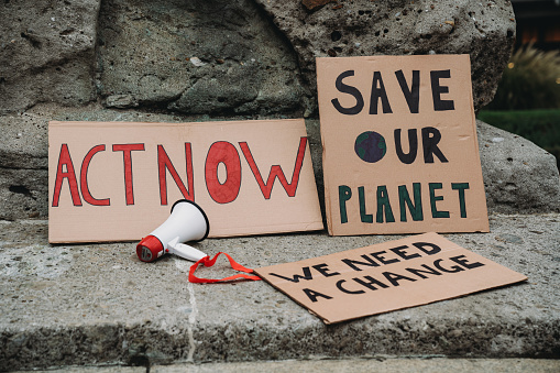 Detail of cardboard signs resting on the ground in a protest against climate change. Demonstration against global warming concept.