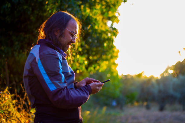 istock Biker man using phone on plateau in sunset light 1345179023