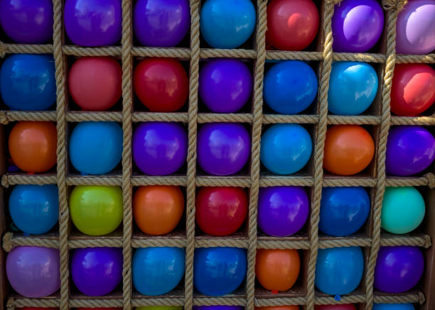 molti palloncini colorati in gabbie quadrate per giocare a freccette. - rubber dart foto e immagini stock