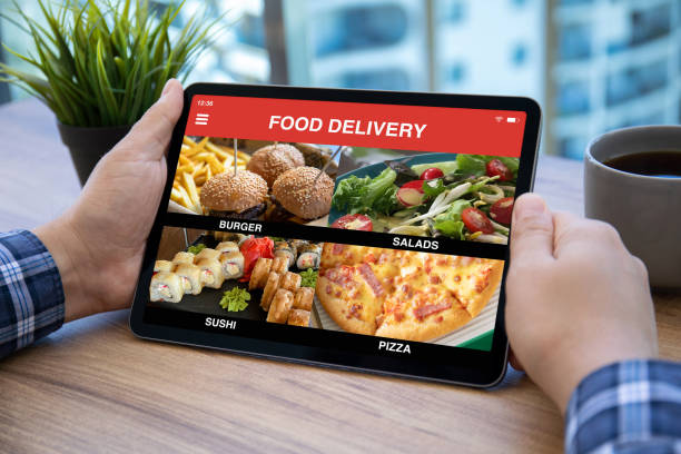 istock male hands holding computer tablet with with app food delivery 1345182948