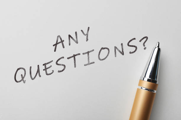 istock Phrase ANY QUESTIONS and pen on white paper, top view 1345184786