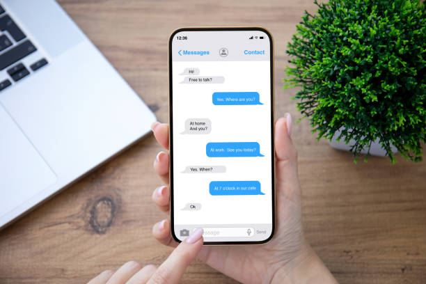 istock female hand holding phone app messenger over table in office 1345185753