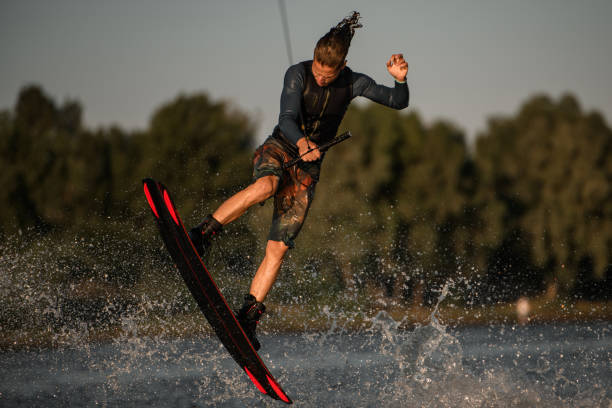 istock male wakeboarder having fun and jump on the board at splashing river wave 1345187692