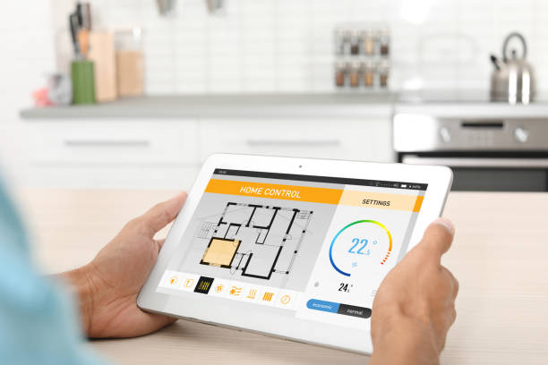 istock Energy efficiency home control system. Man using tablet to set indoor temperature, closeup 1345188349