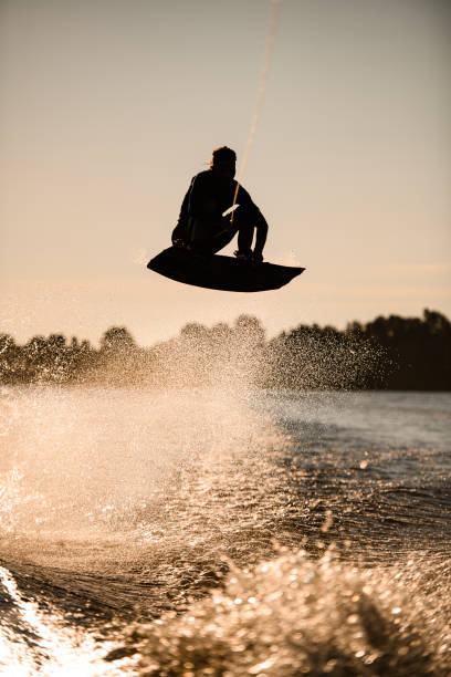 istock wakeboarder athlete man jumping high making tricks in the air 1345188514