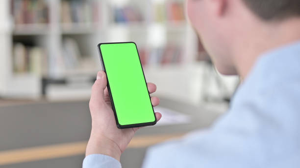 istock Man Holding Green Chroma Key Smartphone Screen 1345189237