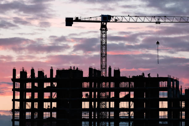 istock Tower crane, workers work at construction site. Process of building new houses 1345190331