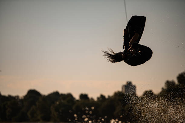 istock Active athletic male wakeboarder jumps and makes dangerous stunts with board 1345191048
