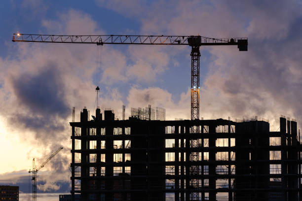 Tower crane, workers work at construction site. Process of building new houses