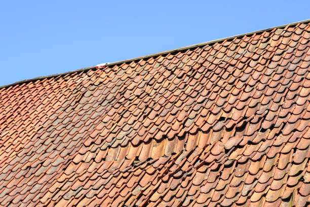 istock clay tile roof damage, some fallen tiles 1345191848