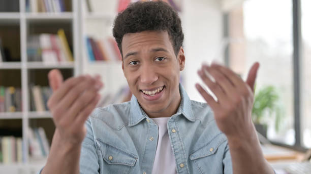 istock Welcoming Young African American Man Pointing at the Camera, Inviting 1345192826
