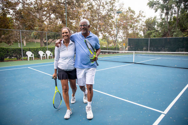 Senior Black Couple on Tennis Court A senior black couple together on the tennis court. tennis senior adult adult mature adult stock pictures, royalty-free photos & images