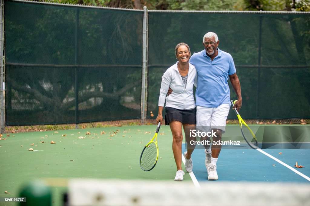 Senior Black Couple on Tennis Court A senior black couple together on the tennis court. Tennis Stock Photo