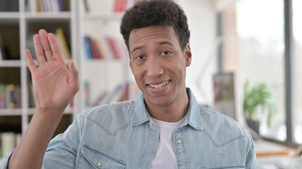 istock Delighted Young African American Man Waving, Saying Hello 1345193793