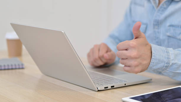istock Thumbs up by Man Typing on Laptop, Close up 1345193867