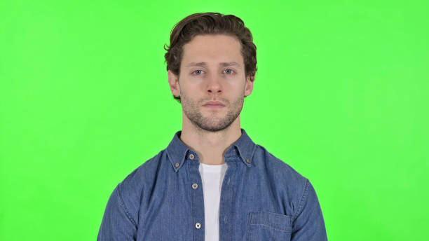istock Serious Young Man Looking at the Camera on Green Chroma Key 1345195533