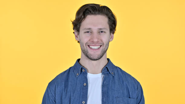 istock Young Man Smiling at the Camera on Yellow Background 1345195713